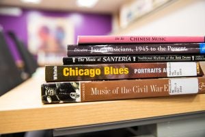 a selection of musical books on civil war, Chicago blues, Santeria rhythms, jazz, and Chinese music stacked on a table. 