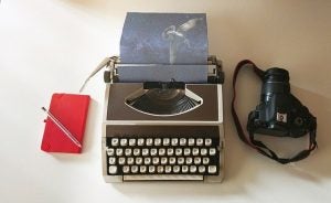 photo of typewriter, journal, and camera 