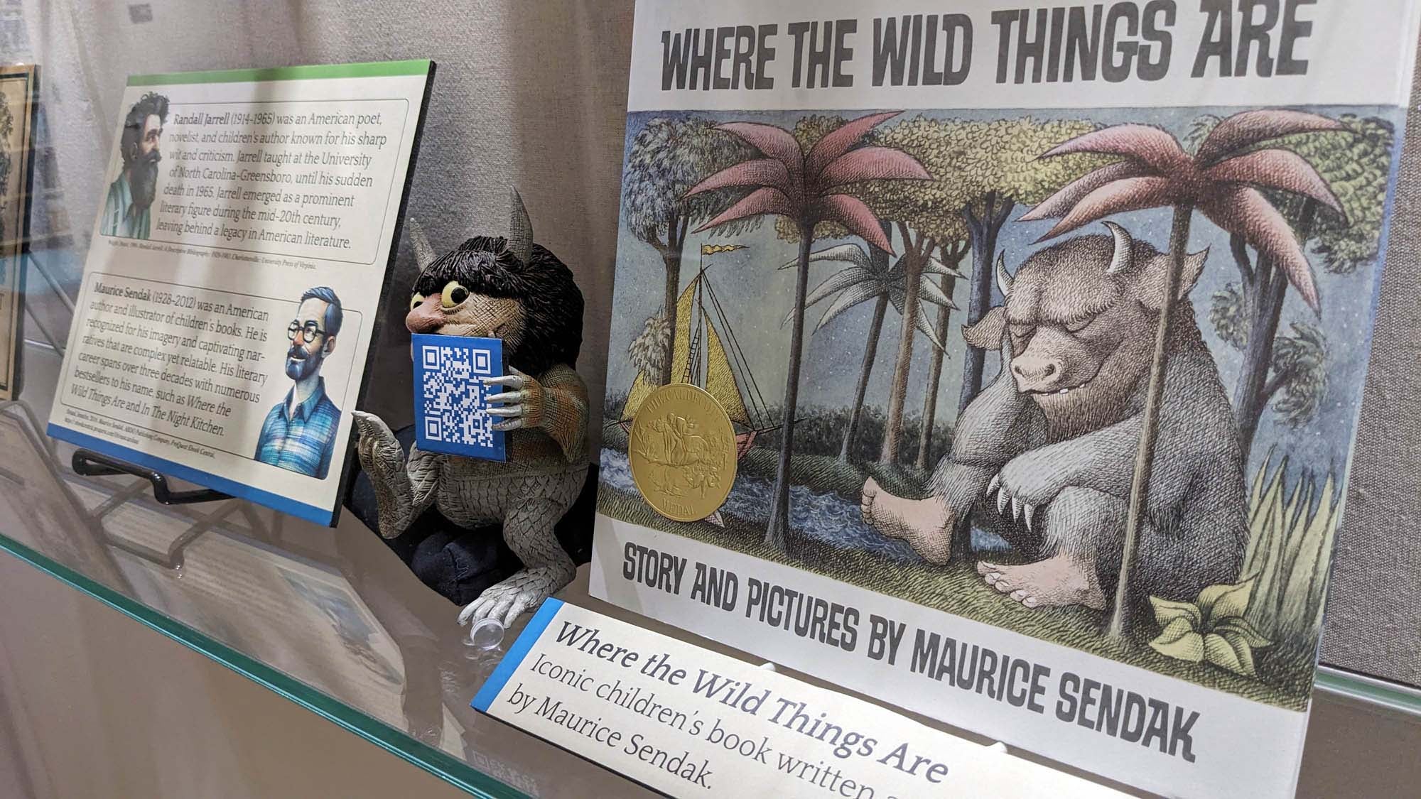 Picture of the book Where the Wild Things Are and a figurine as displayed in the exhibit.