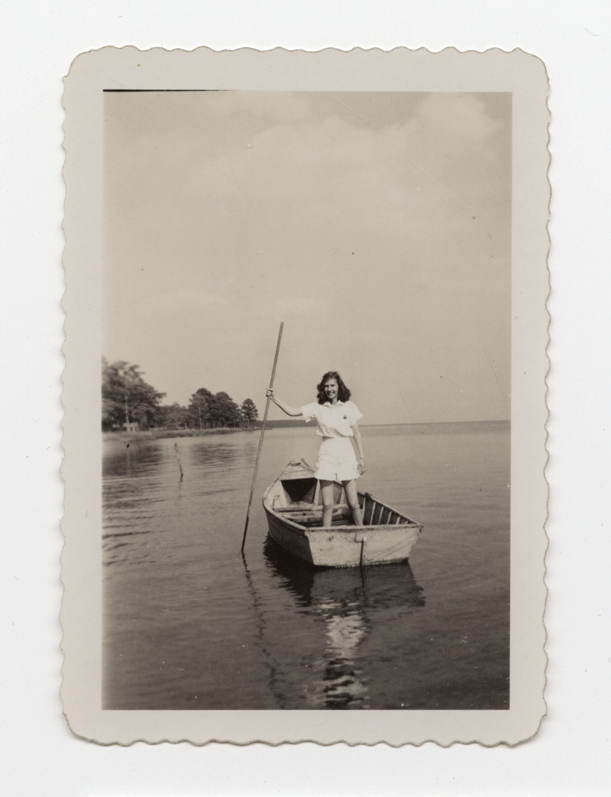 Woman standing in canoe on water