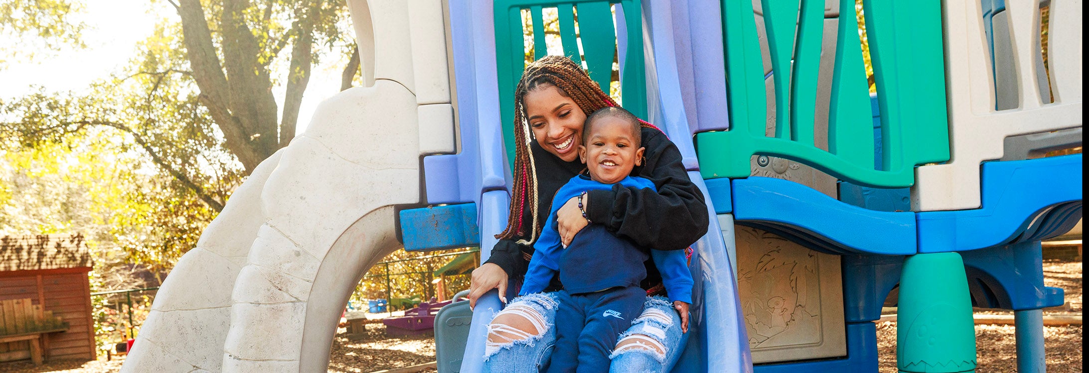 Kamryn Simmons slides with her son, Kamori, on the playground at the Nancy Darden Child Development Center. (ECU News photo by Steven Mantilla)