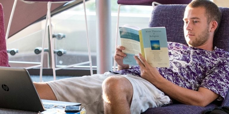 Dustin Hendriz reads a book while relaxing on the second floor of the Health Sciences Student Center on Wednesday evening. (ECU Photo by Rhett Butler)