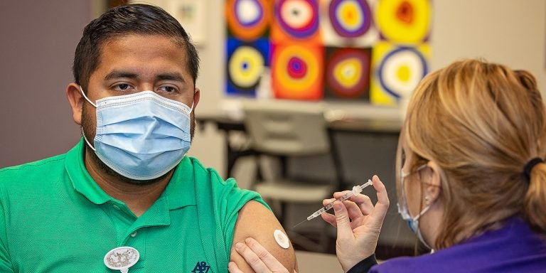 Jonathan Mendez gets vaccinated in the Brody Commons on Jan. 13, 2021, by Erica Turner, RN. (ECU Photo by Cliff Hollis)