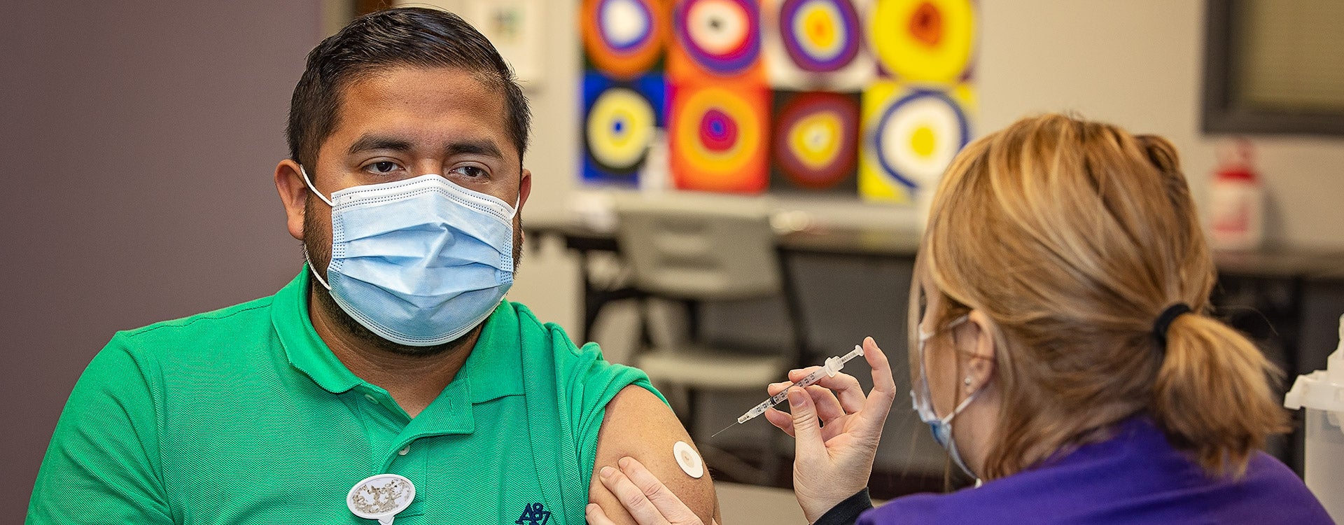 Jonathan Mendez gets vaccinated in the Brody Commons on Jan. 13, 2021, by Erica Turner, RN. (ECU Photo by Cliff Hollis)
