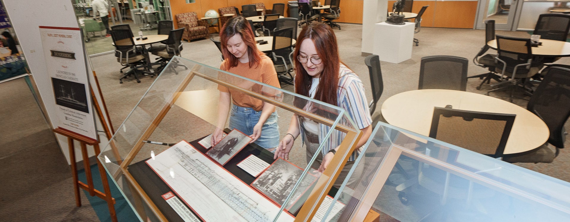 Kendra Ellis, left, and Katelyn Rollins work on a display dedicated to late professor Ralph Scott. (ECU Photos by Cliff Hollis)