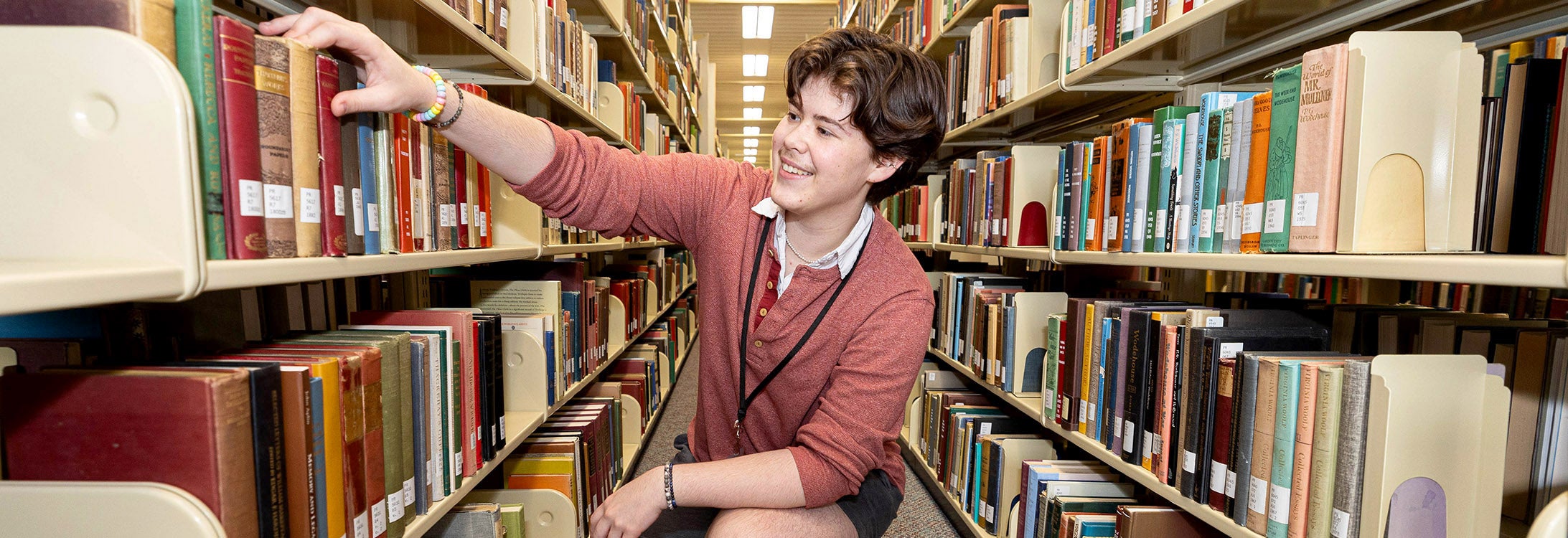 Wren Holbrook, a graduate circulation assistant, reshelves a book in the library. (Photos by Rhett Butler)