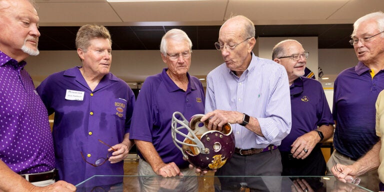 Grover Truslow talks to East Carolina University football teammates about the helmet he wore in the 1970 ECU-Marshall game. ECU and Marshall play this weekend at 4 p.m. at Dowdy-Ficklen Stadium. (ECU photos by Rhett Butler)