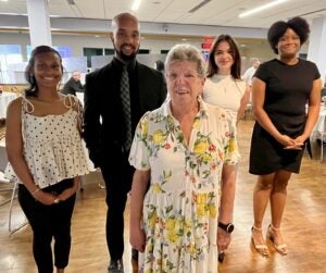 Marie Thompson stands with 2025 award winners three women and one man.